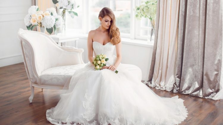 Bride Sitting Long Wedding Dress Strapless Holding Flowers