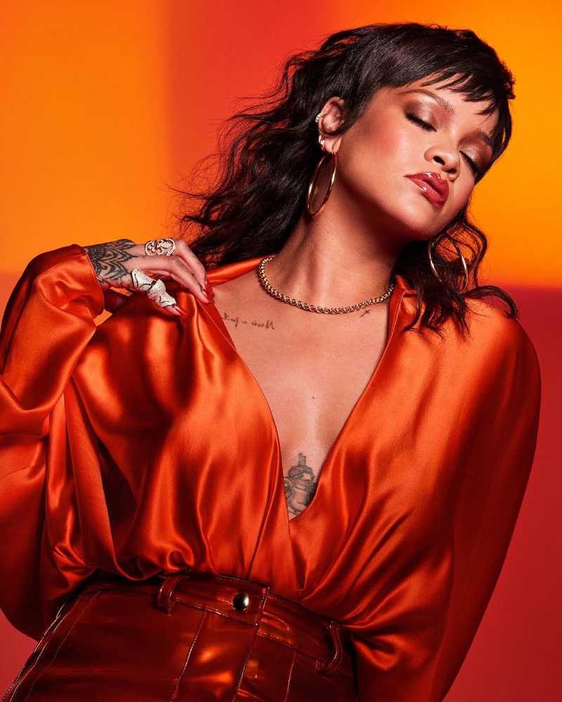 Showing off her tattoos, Rihanna fronts Fenty Beauty Gloss Bomb Heat campaign.