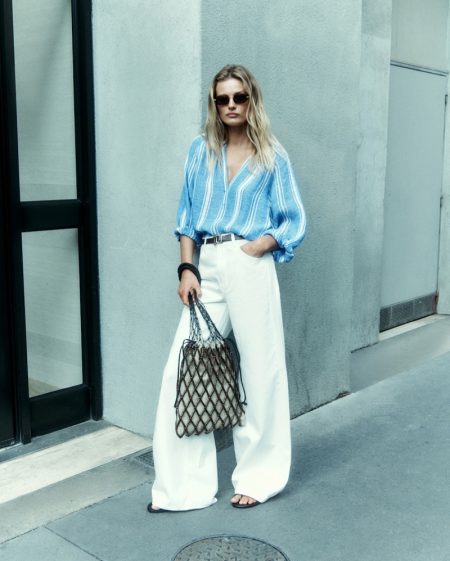 Sunset: Edita Vilkeviciute Poses in Massimo Dutti's Summer Essentials Massimo Dutti Striped Shirt with Polo Collar, Trousers, Braided Leather Tote Bag, and Leather Sandals with Asymmetric Upper.