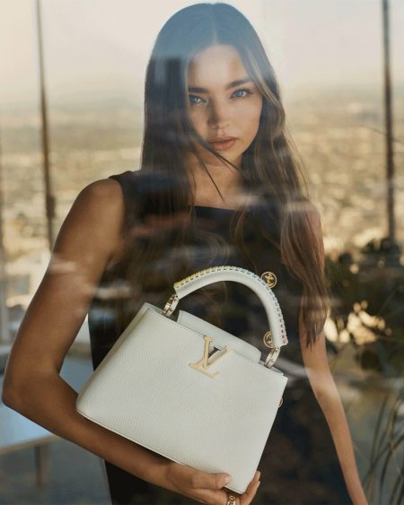 Miranda Kerr Poses in L.A. With Louis Vuitton Capucines Bag Posing by a window, Miranda Kerr fronts Louis Vuitton Capucines 2021 campaign.