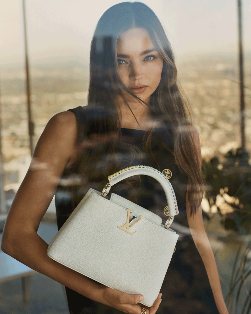 Posing by a window, Miranda Kerr fronts Louis Vuitton Capucines 2021 campaign.