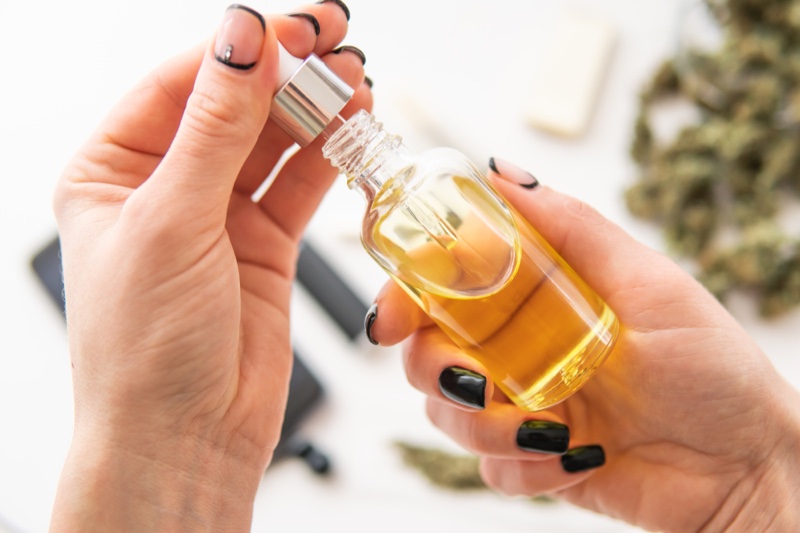 Woman Holding CBD Bottle Manicured Nails