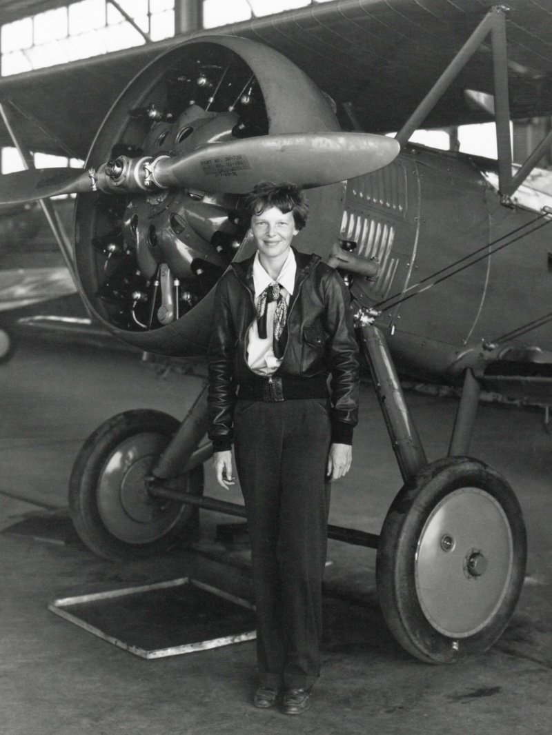 Aviator Amelia Earhart wears pants in a 1936 photo while posing next to an airplane. Photo: Shutterstock.com