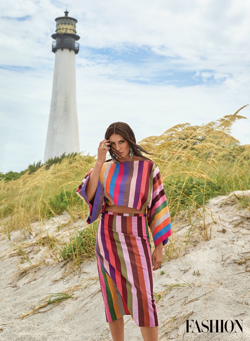 Wearing colorful stripes, Ashley Callingbull poses in 4Kinship top and skirt.