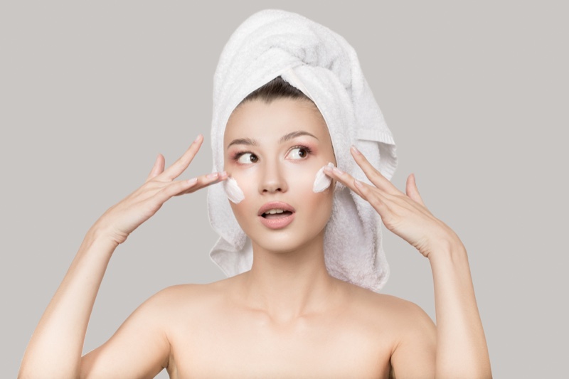 Model Applying Moisturizer Face Skincare Towel