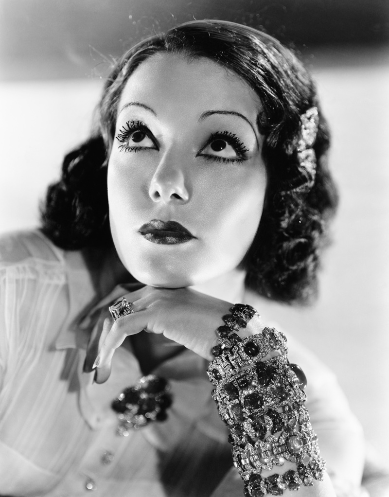 Woman poses with bold and big jewelry circa the 1930s.