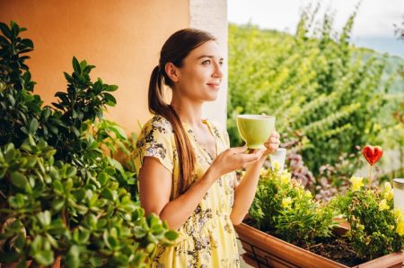 4 Tips for Staying on a Healthy Diet Young Woman Holding Green Tea Cup Yellow Dress Plants