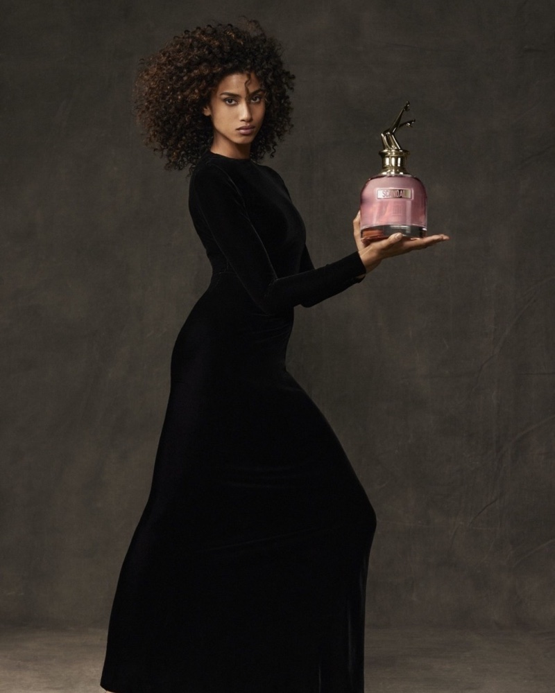 Model Imaan Hammam poses with Jean Paul Gaultier Scandal fragrance bottle.