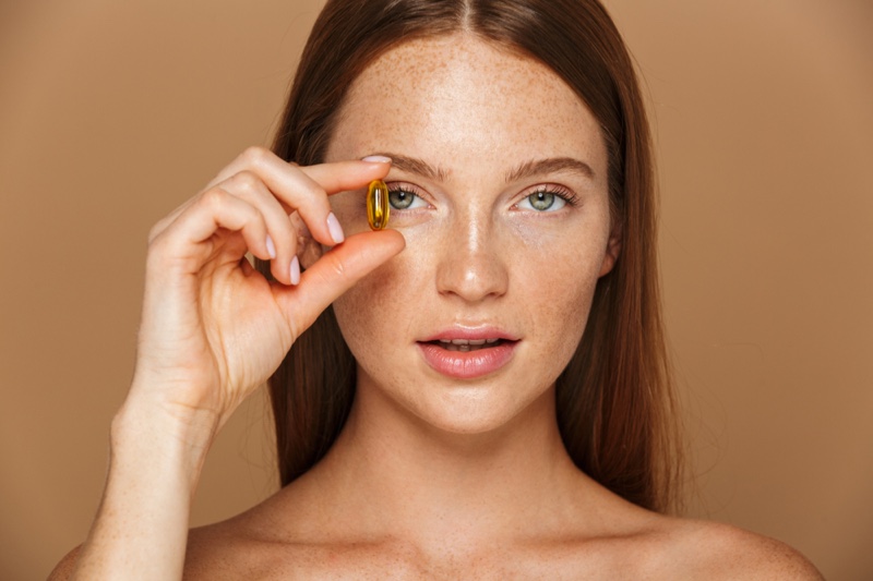 Model Freckled Face Holding Vitamin Gel