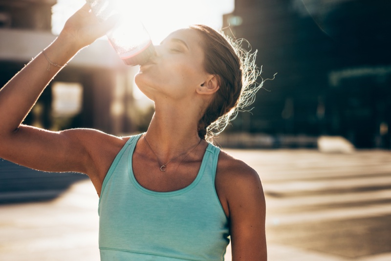 Woman Drinking Water Outside Sun