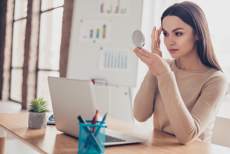 Woman Looking at Makeup in Mirror