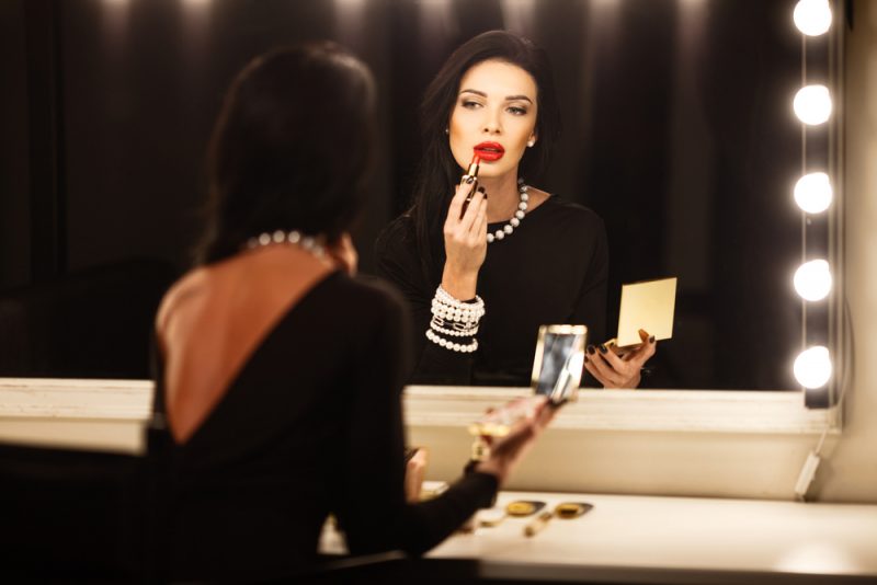 Woman in Black Dress and Pearls Red Lipstick