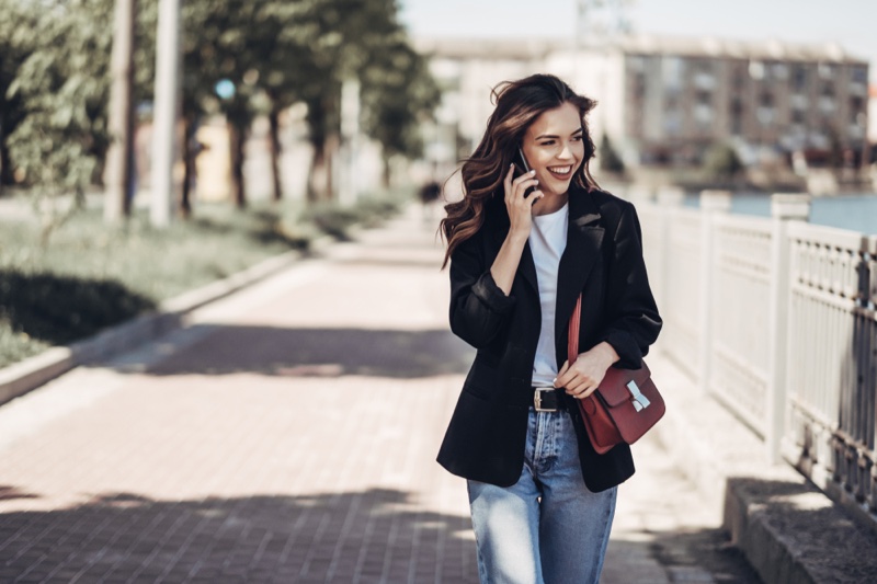 Young Woman Smiling Phone Blazer Jeans Outfit