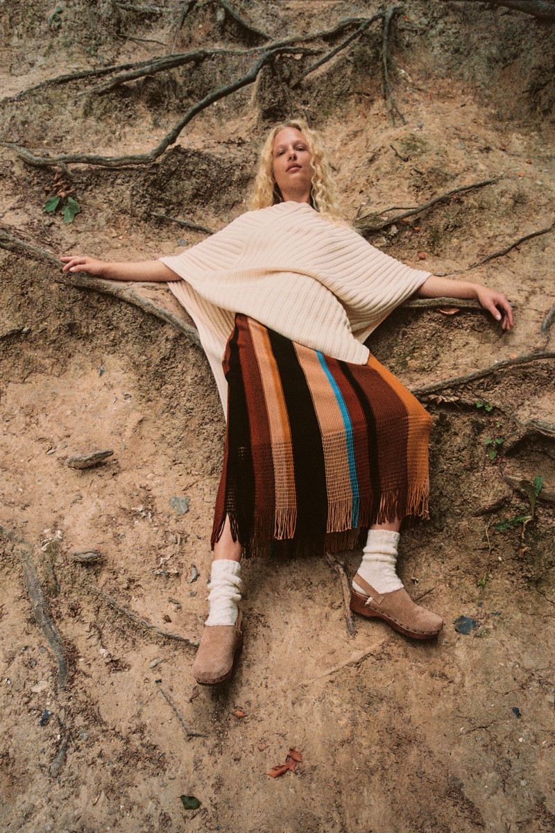 Frederikke Sofie models Zara Asymmetric Long Cape, Striped Knit Skirt, and Split Leather Clogs.