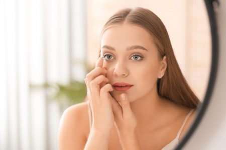Five Straightforward Tips for Transitioning From Glasses to Contact Lenses Blonde Woman Putting On Contact Lenses