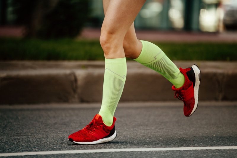 Cropped Woman's Legs Running Green Socks Red Sneakers
