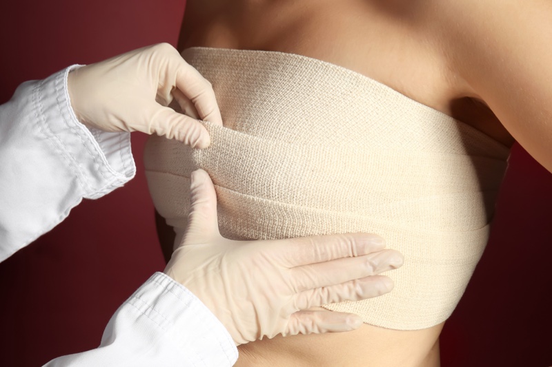 Doctor Bandaging Woman's Breasts