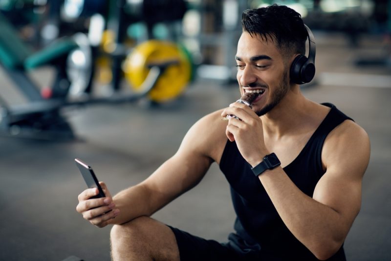 Man Listening to Music on Wireless Headphones Gym