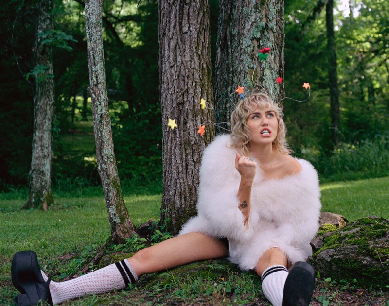 Posing underneath a tree, Miley Cyrus models Gucci coat, socks, and shoes. Photo: Brianna Capozzi/Interview, Courtesy Columbia Records