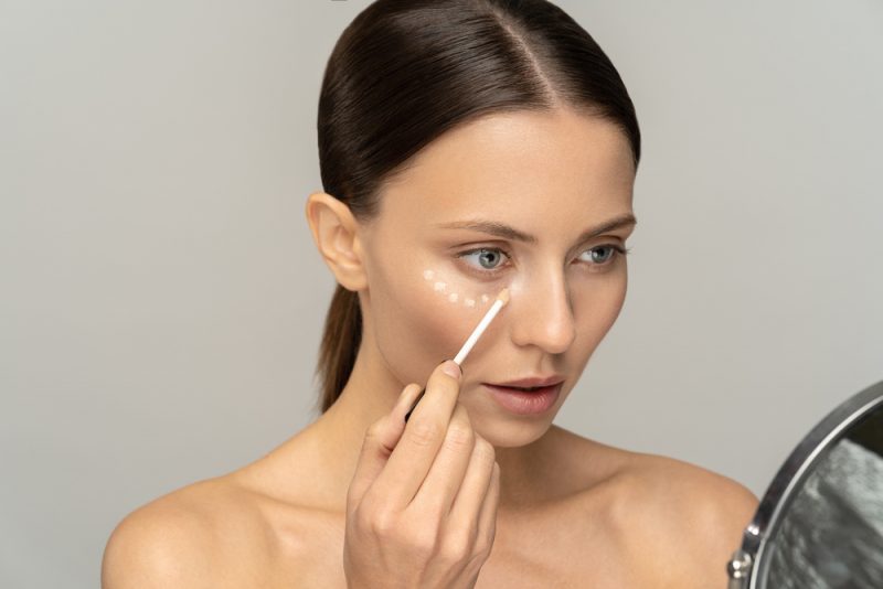 Woman Putting on Concealer