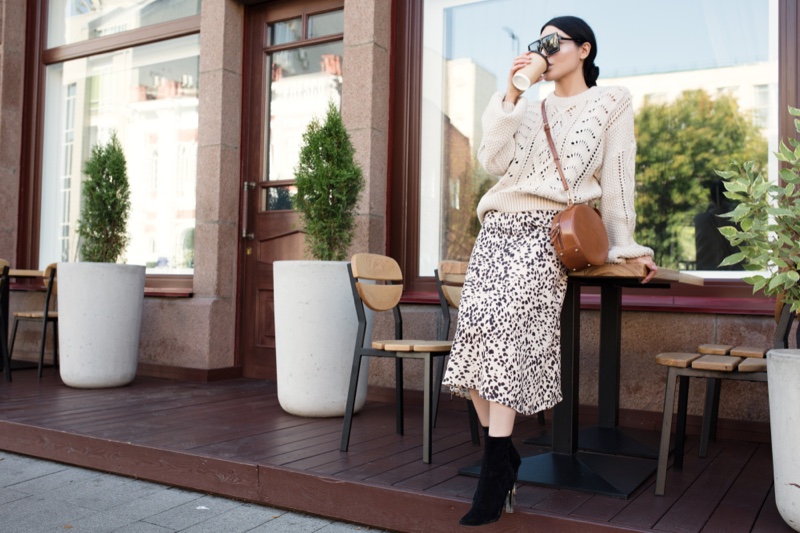 Woman White Sweater Print Skirt Outfit Drinking Coffee