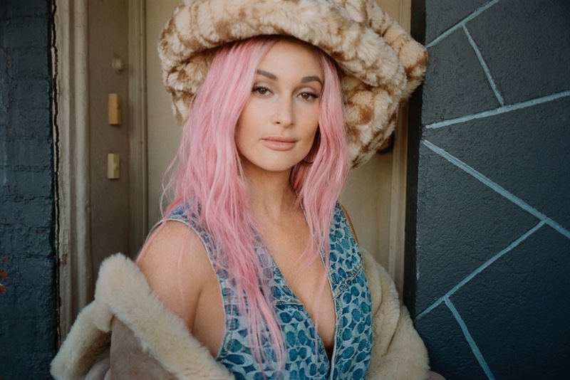 Singer Kacey Musgraves poses in Coach clothing and hat with Jennifer Fisher earrings. | Photo Credit: Courtesy of V Magazine / Blair Getz Mezibov