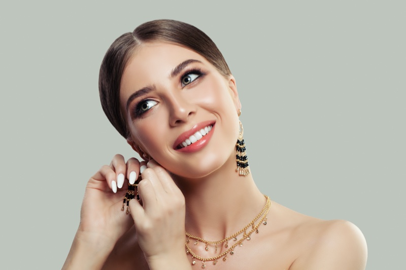 Smiling Model Putting Earrings Jewelry