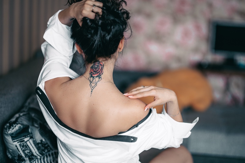 Woman Showing Red Rose Tattoo Back Neck