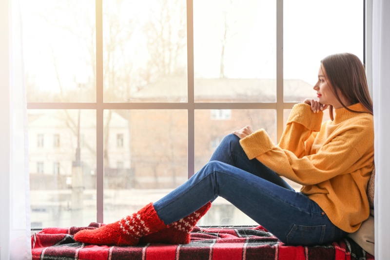 Woman Window Sill Yellow Sweater Jeans Red Winter Socks