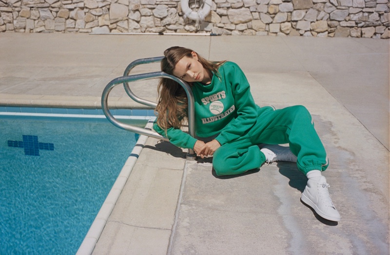Posing poolside, Josephine Skriver wears green sweatsuit from Nasty Gal x Sports Illustrated collaboration.