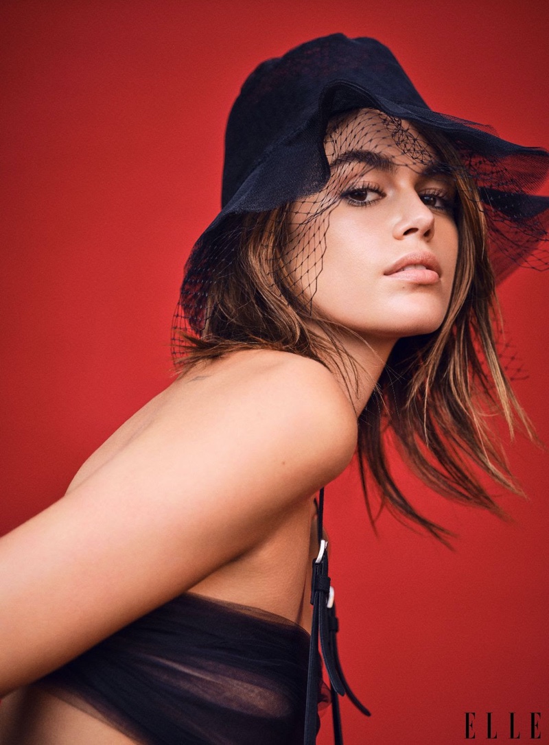 Kaia Gerber poses in Dior hat with Emporio Armani suspender pants. Photo: Nathaniel Goldberg / ELLE US