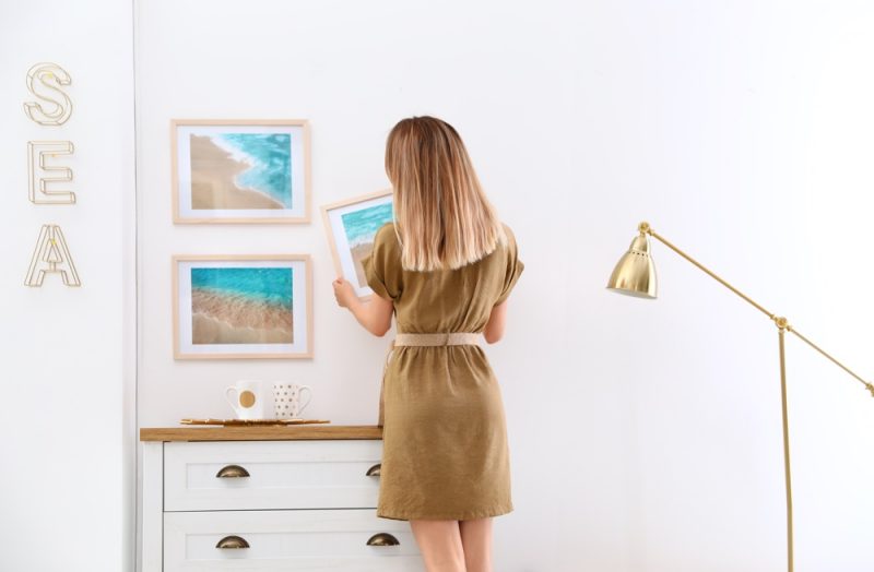 Woman Decorating Home Hanging Pictures