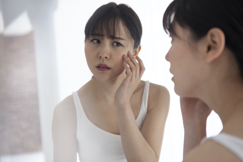 Asian Woman Checking Face Breakout Bangs