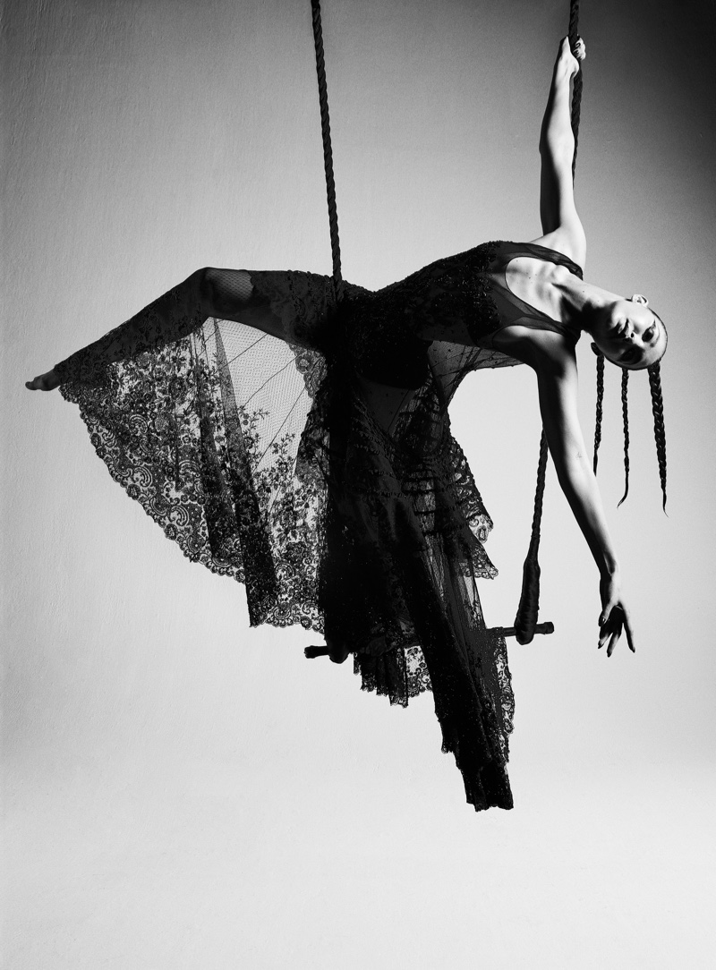 Posing on a trapeze, Gigi Hadid wears a Louis Vuitton dress. | Photo Credit: Courtesy of V Magazine / Mario Sorrenti
