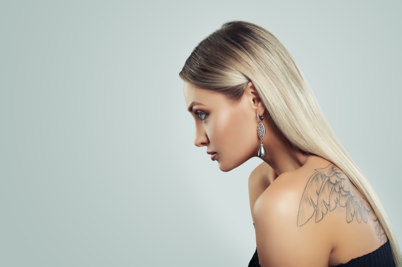 Side View Blonde Model Earring Wings Tattoo