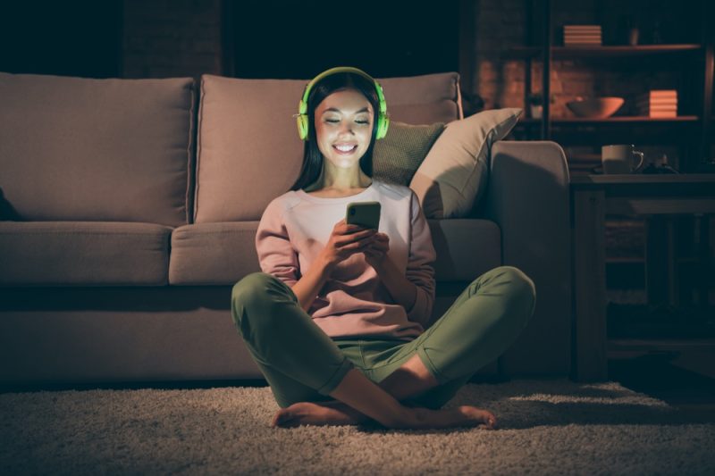 Woman Leisure Evening Playing on Phone Headphones