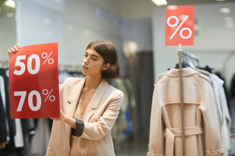 Woman Putting Sale Sign Clothing Store Window