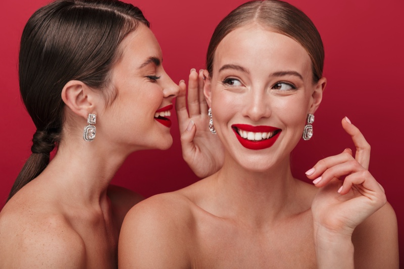 Two Models Red Lipstick Earrings Smiling Teeth