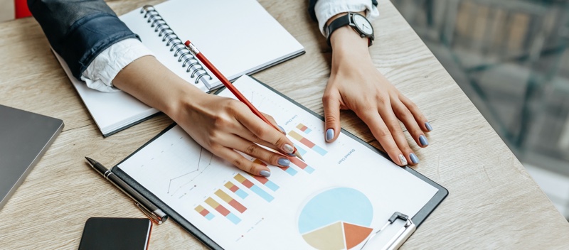 Woman Painted Nails Looking Charts