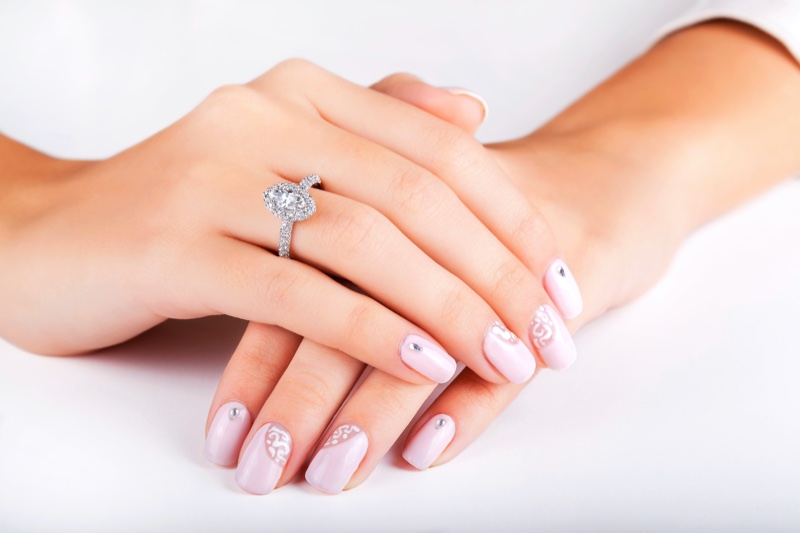 Woman Pink Manicure Engagement Ring Halo