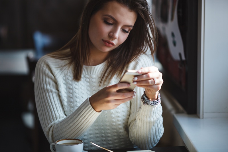 Attractive Woman Checking Phone Sweater App