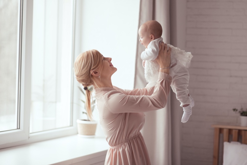 Blonde Woman Holding Baby Pink Dress