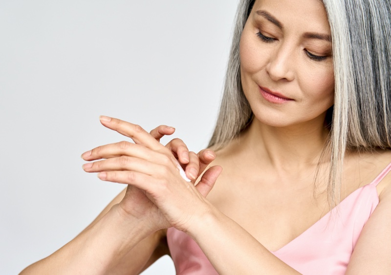 Older Asian Woman Applying Lotion Hands