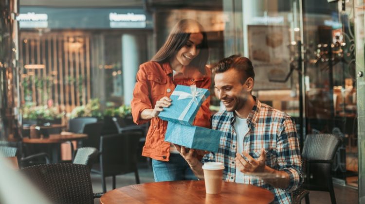 Woman Giving Man Gift Cafe