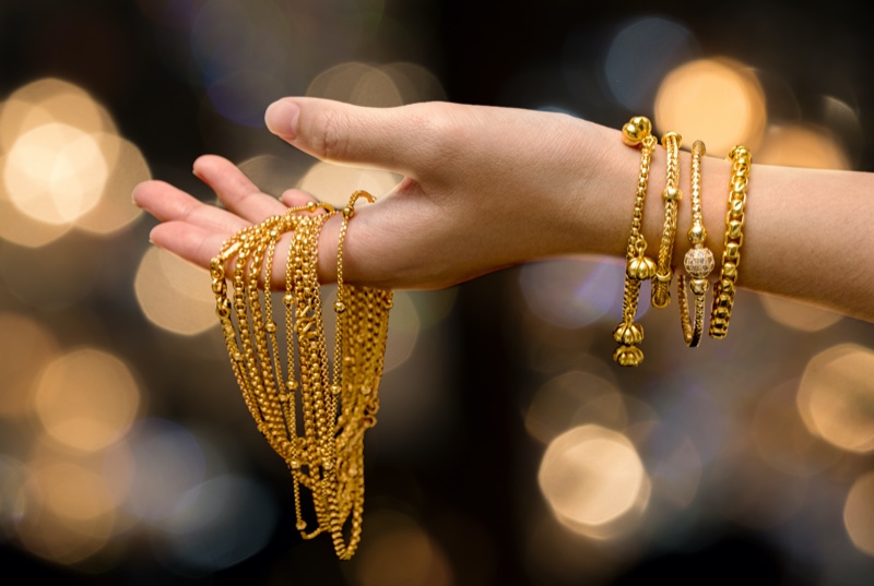 Woman Holding Gold Jewelry Chains Bracelets