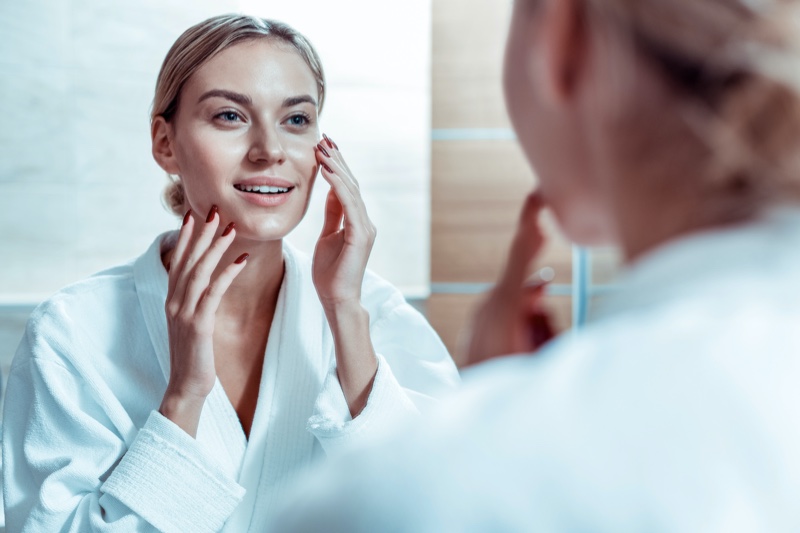 Blonde Woman Checking Skin Mirror