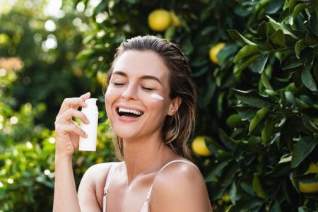 10 Ways to Maintain a Youthful Appearance Happy Model Applying Sunscreen