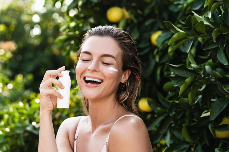 Happy Model Applying Sunscreen