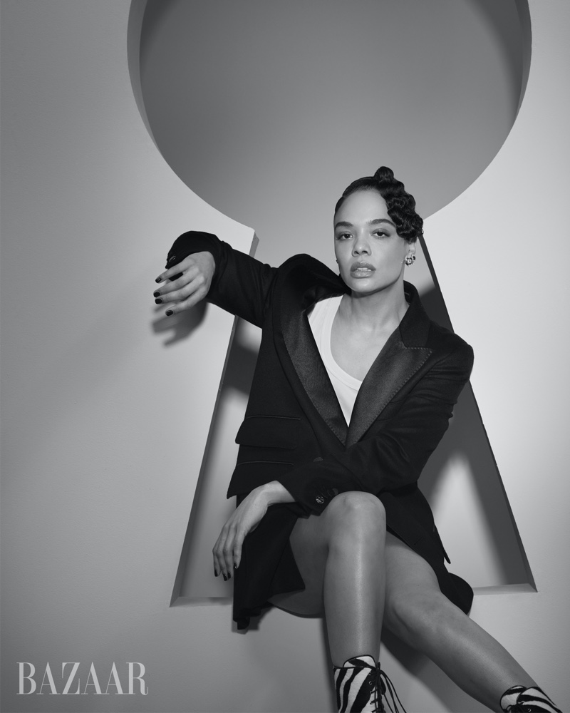 Tessa Thompson poses in Max Mara jacket and tank top with Bulgari earrings and Alaia boots.