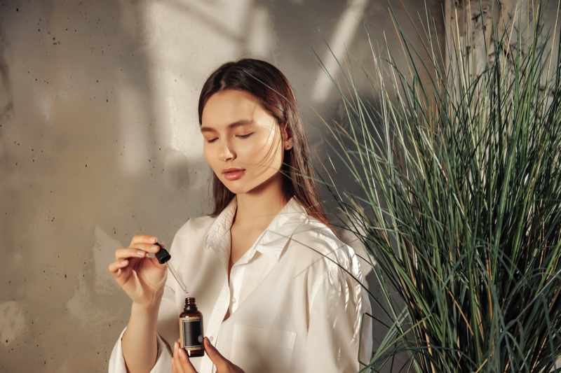 Beautiful Woman Plant Holding Oil Bottle Dropper
